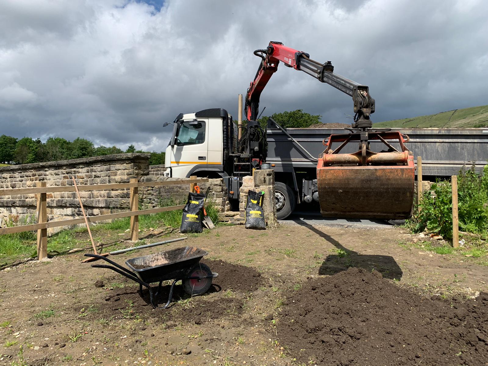 32 Ton rigid grab wagon for hire delivering soil over a wall down a hill